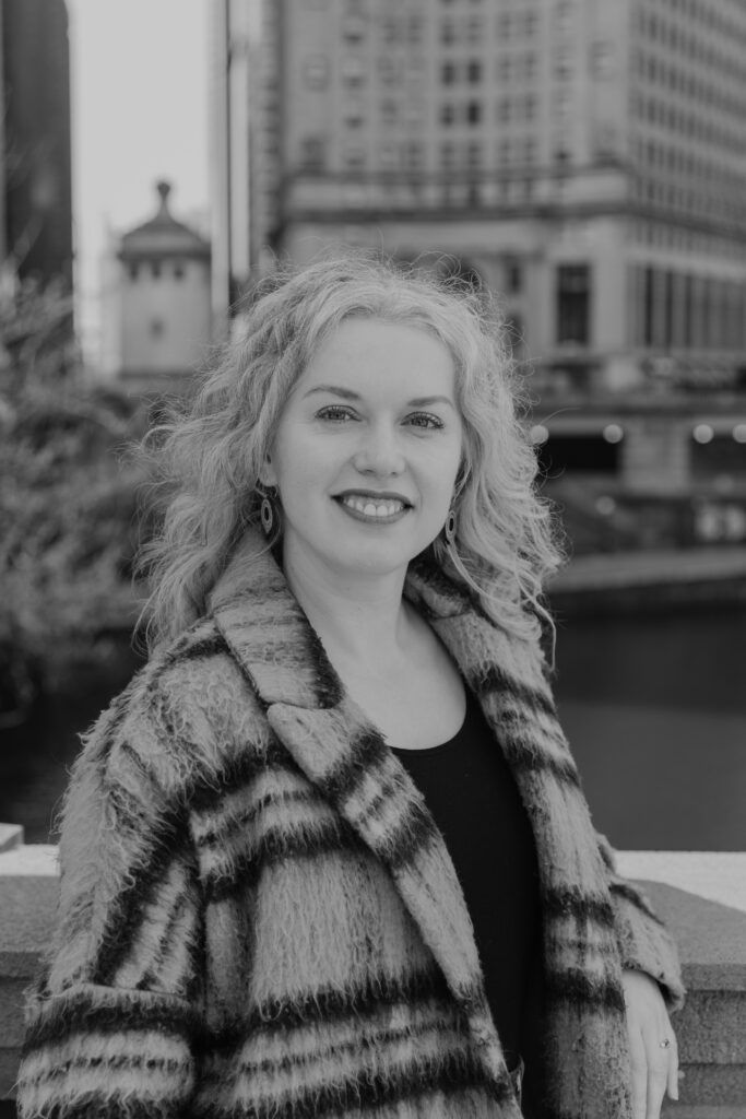 Picture of Ana Pruteanu, Ana is smiling at the camera, skyline of Chicago in background