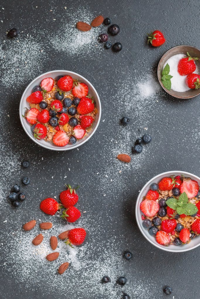 Top view of a bowl of oatmeal with fresh berries on a dark background. Oats are a great source of soluble fiber which can lower cholesterol levels.